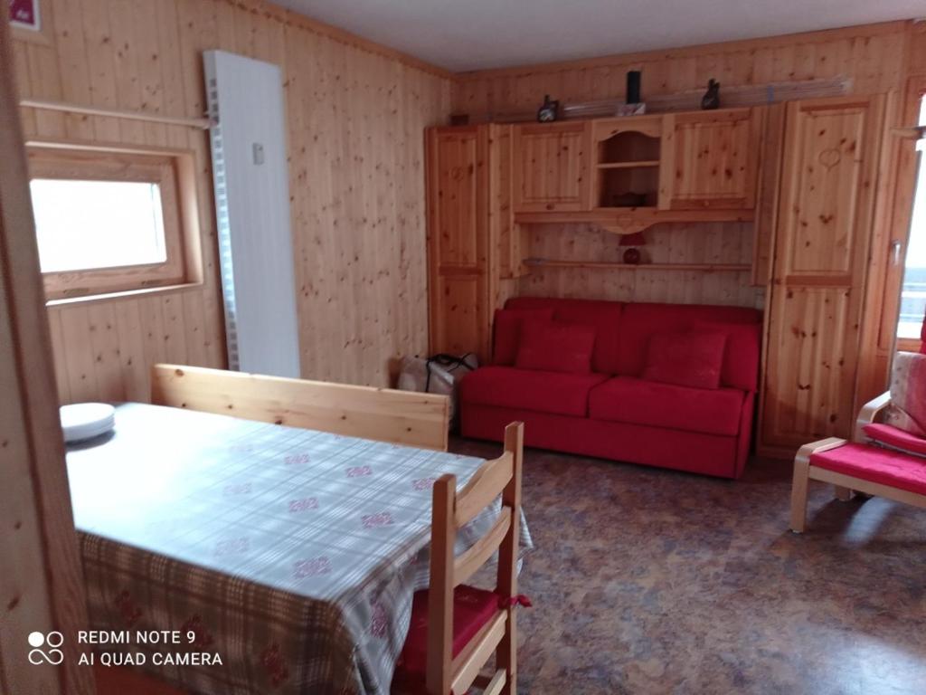 un salon avec un canapé rouge et une table dans l'établissement Appartement de 2 pièces exposé Sud/Ouest avec balcon et vue montagnes à Tignes - FR-1-449-185, à Tignes