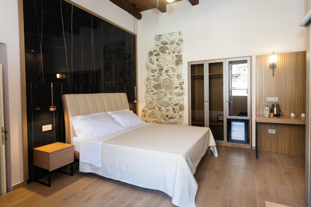 une chambre avec un lit blanc dans une pièce dans l'établissement Heraklean Suites Tropea, à Tropea