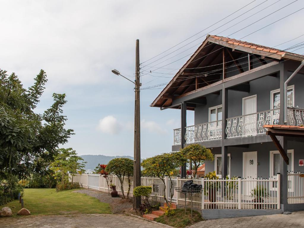 ein Haus mit einem Balkon und einem Zaun in der Unterkunft Unidade do térreo: casa à beira mar XJ6722 in São Francisco do Sul