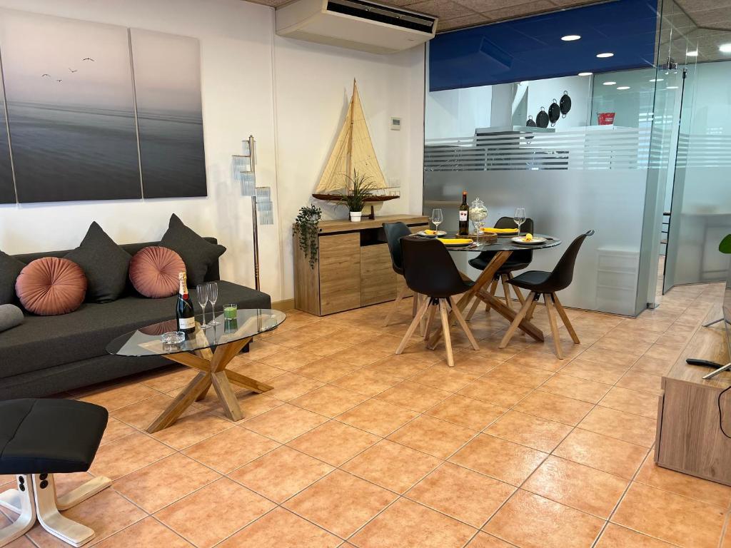 een woonkamer met een bank en een tafel bij Apartamento Nuria,Centro del Pueblo,Planta baja con jardin, Aire Acondicionado in L'Escala