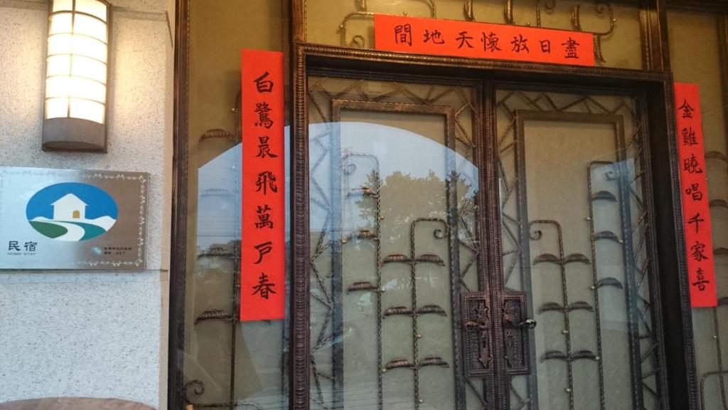 a door to a building with chinese writing on it at LivingGreen B&amp;B in Luodong