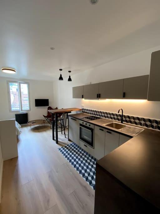 une grande cuisine avec un évier et une table dans l'établissement Appartement moderne & calme Paris Sacré coeur, à Paris