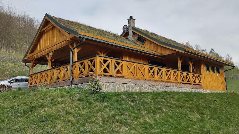 a large wooden building on top of a hill at Pod Zielonym Dachem in Kamienna Góra