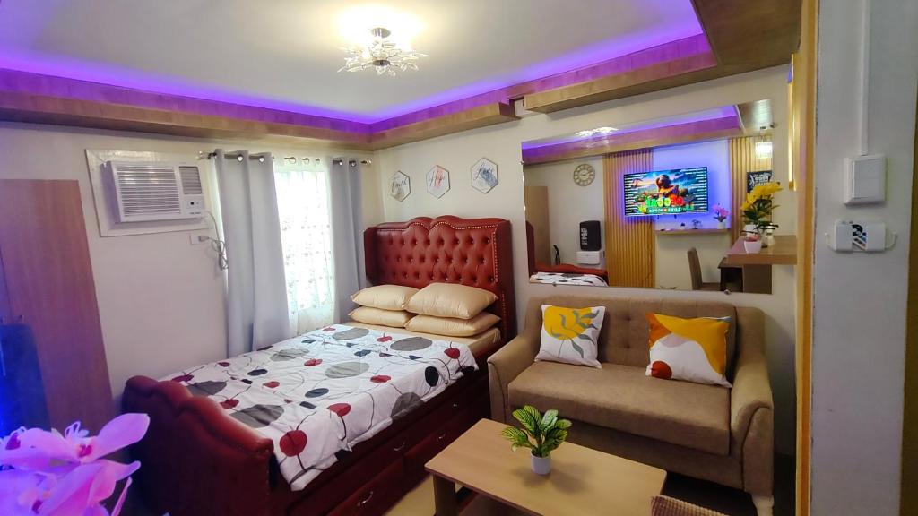 a bedroom with a bed and a couch at Joyful studio unit in Davao City