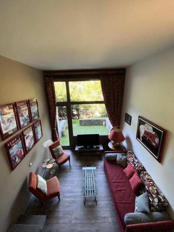 - un salon avec un grand canapé rouge et des fauteuils dans l'établissement Résidence Petaru - Spacieux duplex pour 4 personnes situé à Méribel centre proche des commerces MAE-2143, à Les Allues