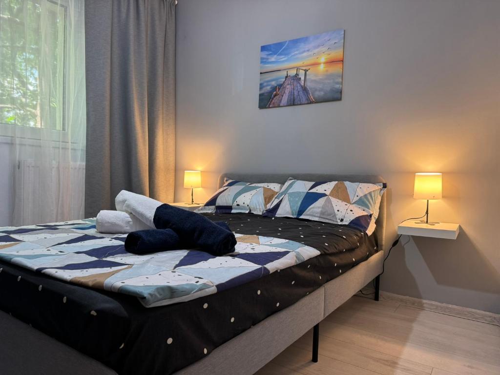 1 cama en un dormitorio con 2 lámparas. en LEX Apartments, en Bucarest