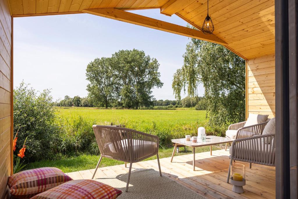 a patio with chairs and a table with a view of a field at 110 Tiny House mit traumhaftem Blick über die Wiese in Bleckede