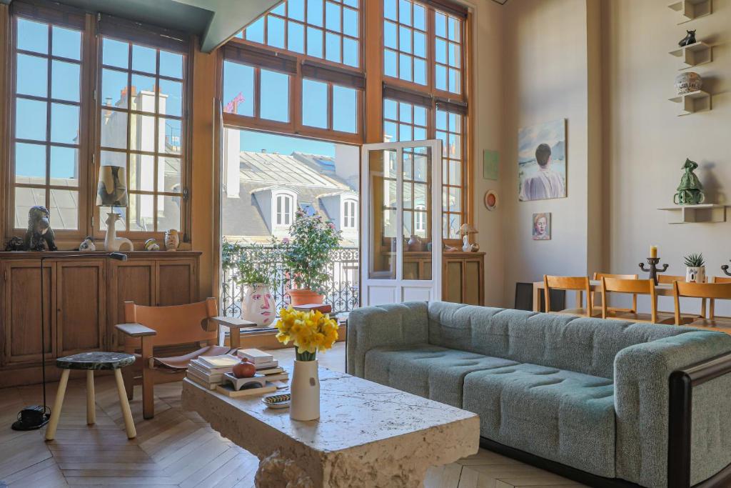 un salon avec un canapé et une table dans l'établissement Parc Monceau Artist's Atelier, à Paris