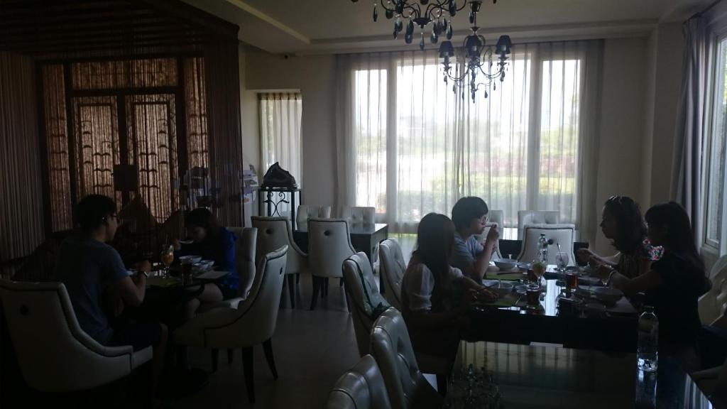 a group of people sitting at tables in a restaurant at LivingGreen B&amp;B in Luodong