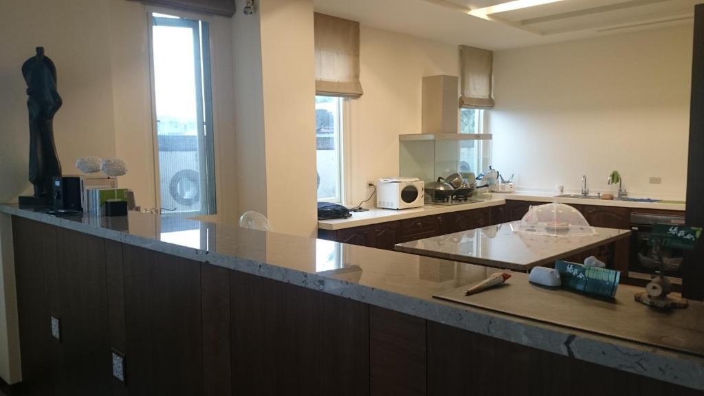 a large kitchen with a counter top in a room at LivingGreen B&amp;B in Luodong