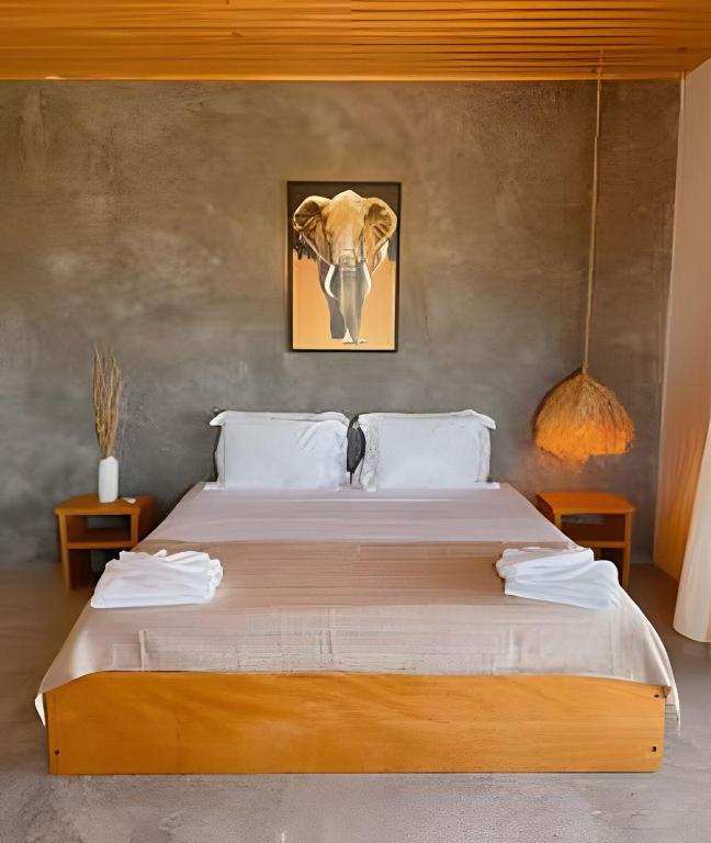 a bedroom with a bed with a picture of an elephant at Casa Caju Tatajuba in Tatajuba