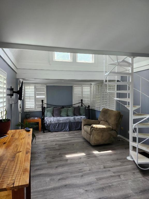 a living room with a bed and a couch and a ladder at Riverfront Cottage in Fox River Grove