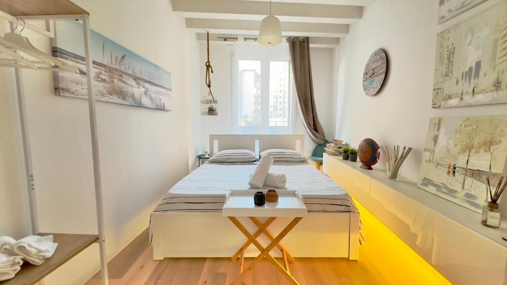 a bedroom with two beds and a table in it at Merlo Holiday Room in Palermo
