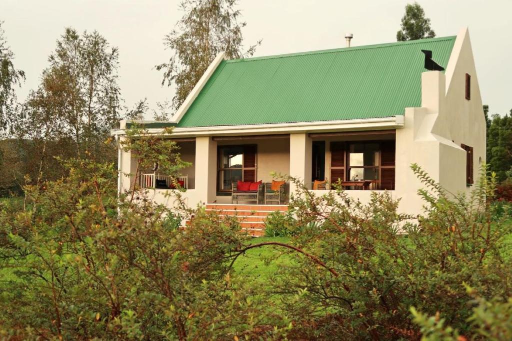 a small white house with a green roof at Trengwainton Cottage in Hogsback
