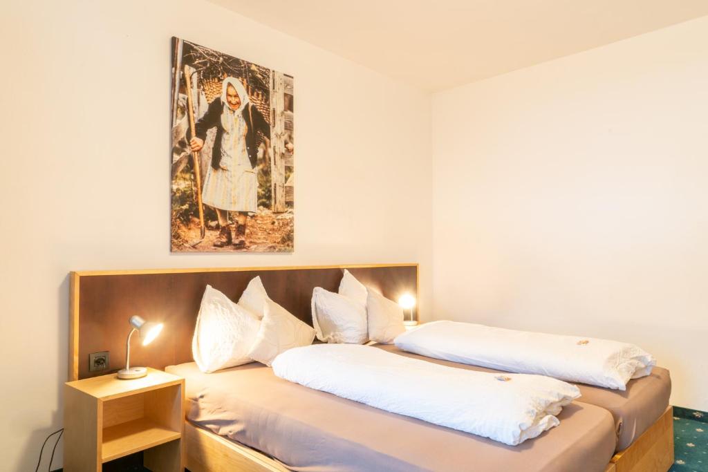 a bedroom with two beds and a painting on the wall at Hotel Martellerhof in Martello