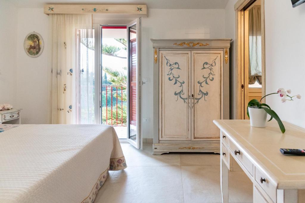 a bedroom with a bed and a door to a balcony at RoRo Home Via Del Mare in Orosei
