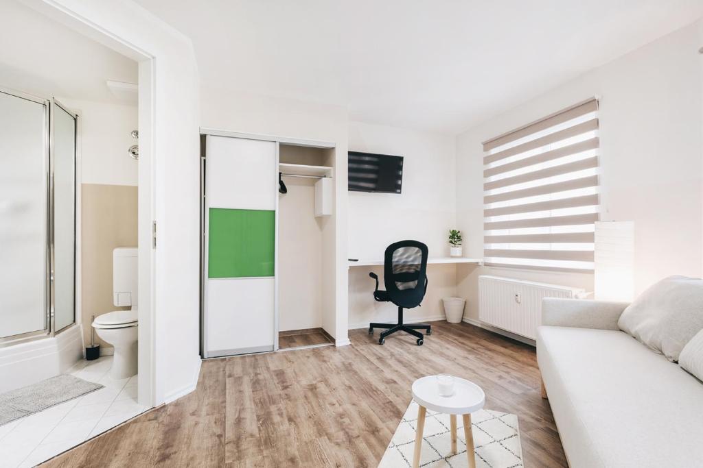 ein Wohnzimmer mit einer Couch und einem Sessel in der Unterkunft Gentilly Apartments Freiberg in Freiberg