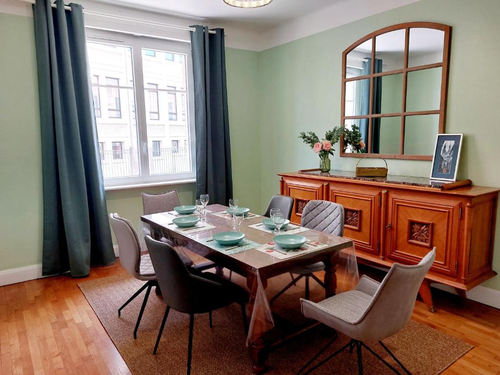 une salle à manger avec une table, des chaises et un miroir dans l'établissement Wellcome to K&A, à Besançon