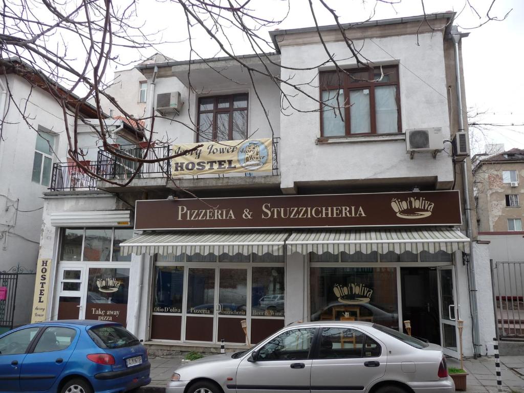 two cars are parked in front of a store at Ivory Tower Hostel in Sofia