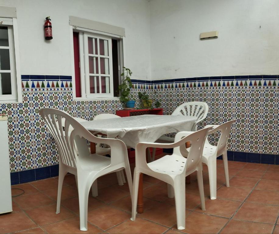 a white table and chairs in a room at Casa Athenea in Conil de la Frontera