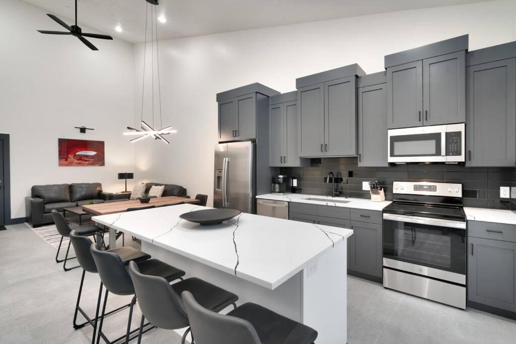 a kitchen with a white counter top and a table at Vizcaya #3 - Moab's Newest Luxury Rental - Private Hot Tub in Moab