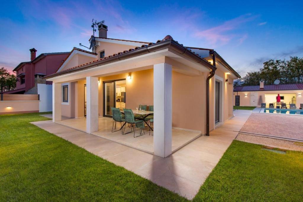 dom z patio ze stołem i krzesłami w obiekcie Villa Jessica w mieście Bibići