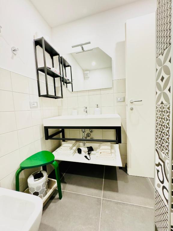 biała łazienka z umywalką i zielonym stołkiem w obiekcie Smart Silver Apartment Central w Bergamo