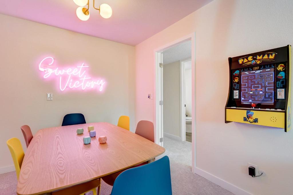コロラドスプリングスにあるRainbow Road Hot Tub Pikes Peak Views Pac Manのテーブルと壁にピンボールマシンが置かれたダイニングルーム