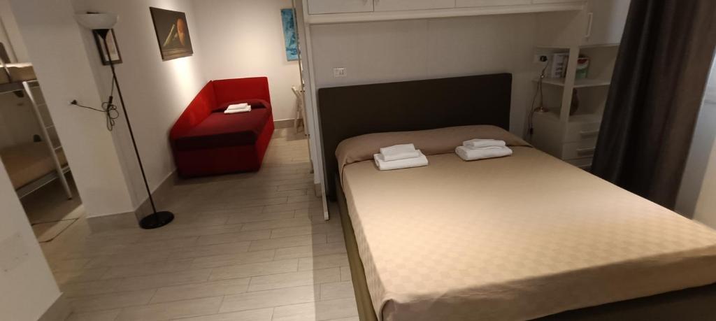 een kleine kamer met 2 bedden en een rode stoel bij Ca Del Gambero Canal View in Venetië