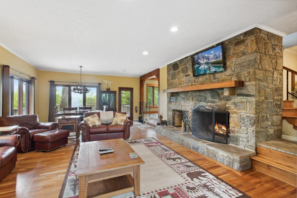 a living room with a large stone fireplace at Ridgeline Views in Boone