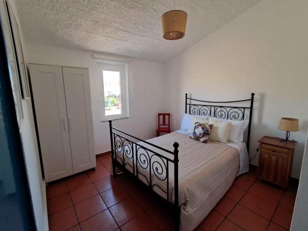 a bedroom with a black bed and a window at Sweet Living Alentejo in Brinches