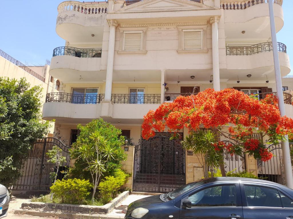a car parked in front of a building with red flowers at Double room in Villa Narges New Cairo in Cairo