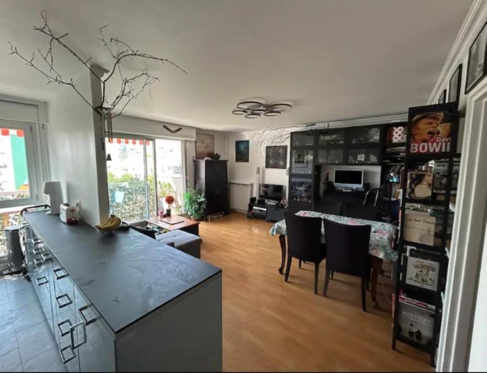 une cuisine et un salon avec une table et des chaises dans l'établissement Appartement familial 3ch balcon Tour Eiffel 15min, à Paris