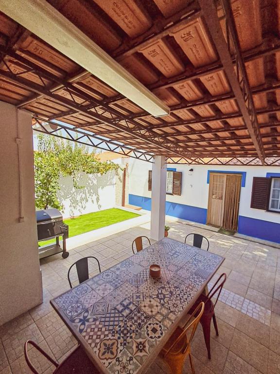 a patio with a table and chairs and a grill at Sweet Living Alentejo in Brinches