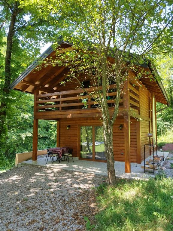 a log cabin with a table and chairs in front of it at Kuća u šumi - Forest house near National park Una - Air Spa Lohovo in Bihać