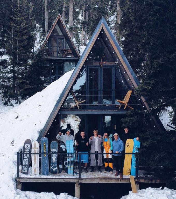 un gruppo di persone che si trovano di fronte a una cabina con snowboard di Bakhmaro A-frame a Chʼkhakoura