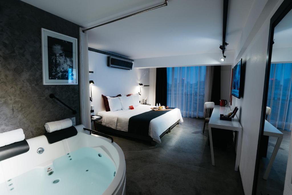 a hotel room with a bed and a bath tub at BTH Hotel &ndash; Boutique Concept in Lima