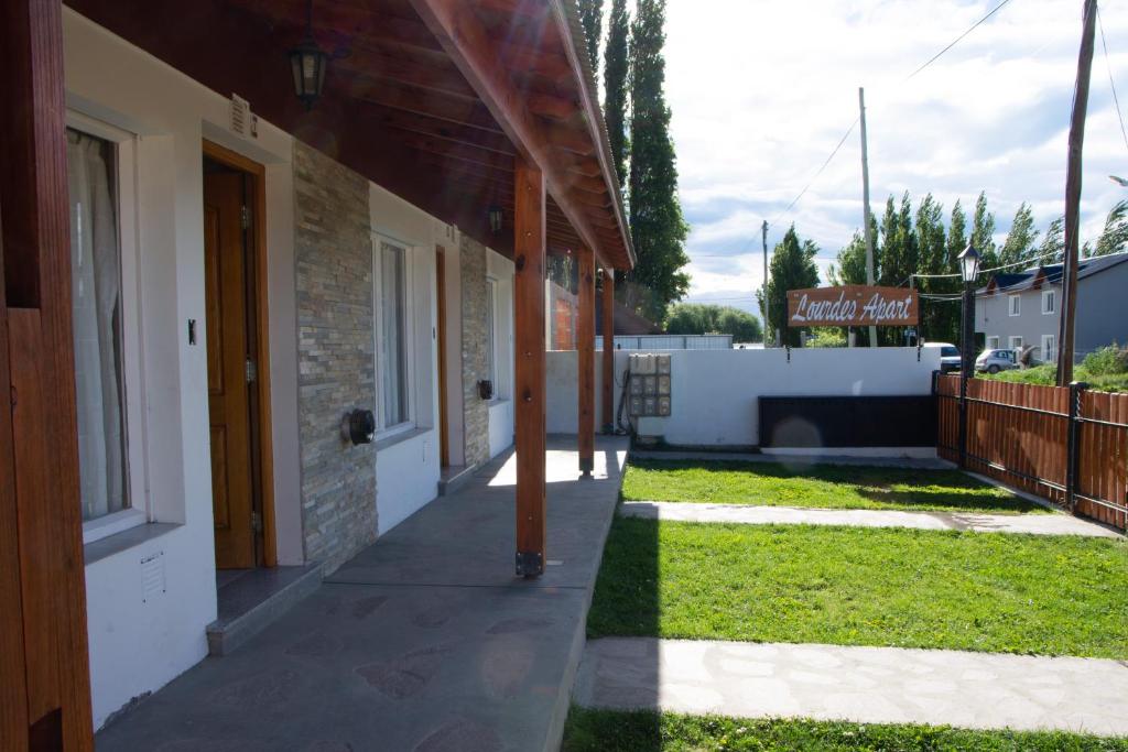 a walkway next to a building with a yard at Apartment Lourdes in El Calafate