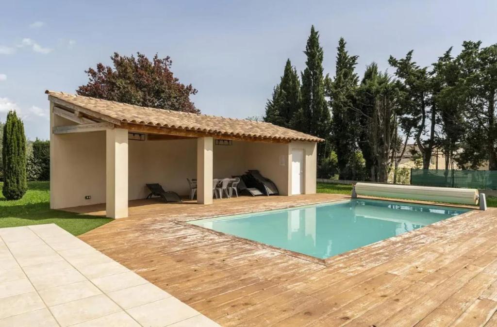 - une piscine avec une terrasse et une maison dans l'établissement Villa spacieuse avec piscine à Saint-Laurent-la-Vernède, à Saint-Laurent-la-Vernède