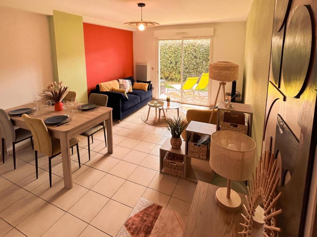 un salon avec une table et un canapé dans l'établissement Élégance Moderne centre, neuf avec jardin, à Gujan-Mestras