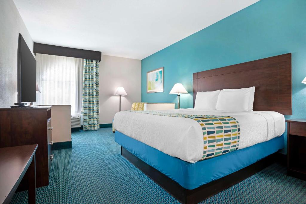 a hotel room with a large bed with blue walls at Best Western Plus Blue Angel Inn in Pensacola