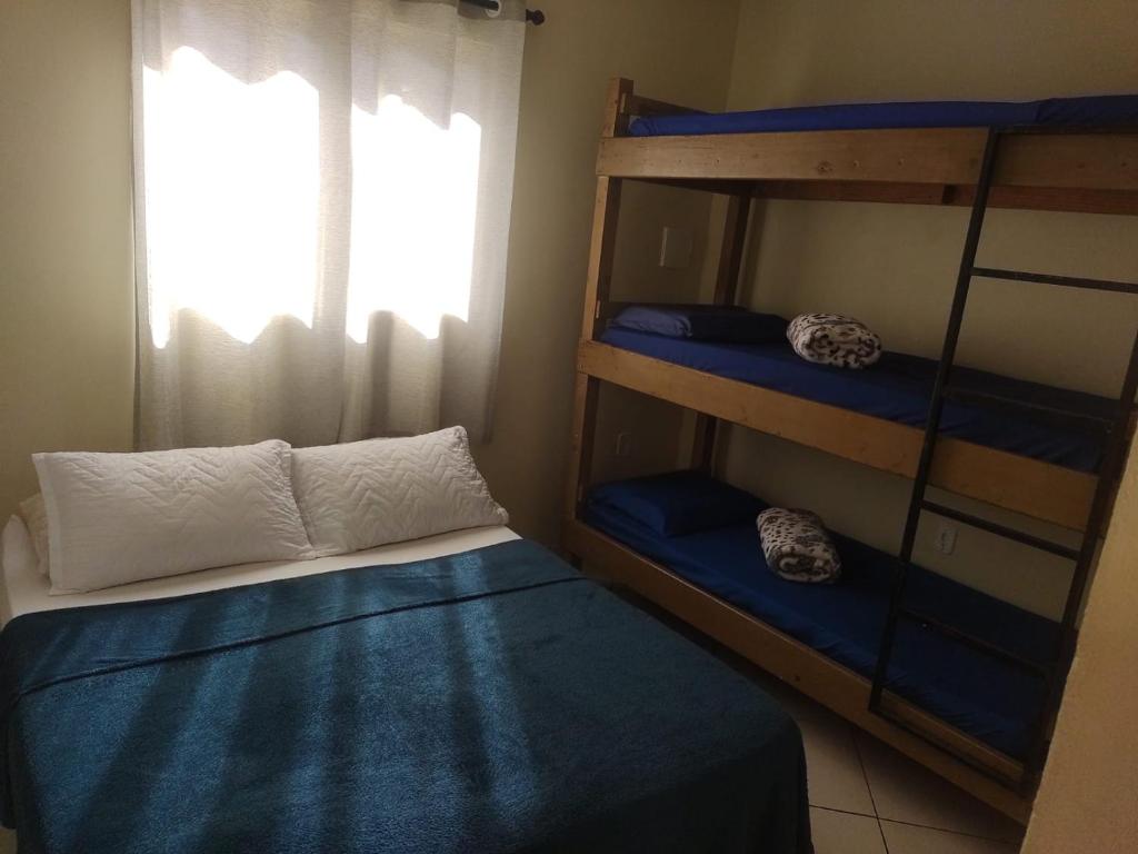 a bedroom with two bunk beds and a window at Casa e Kitnet - Praia Grande Centro in Arraial do Cabo