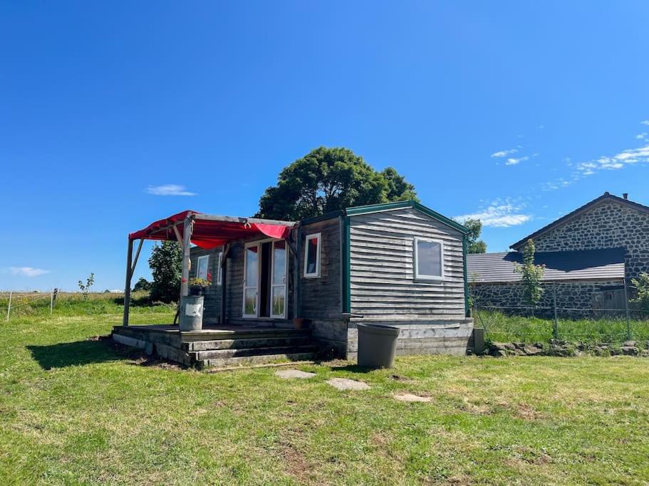 une petite maison avec un toit rouge dans un champ dans l'établissement Bungalow - La Petite Sibérie - Nature - Familial, à Mazet-Saint-Voy