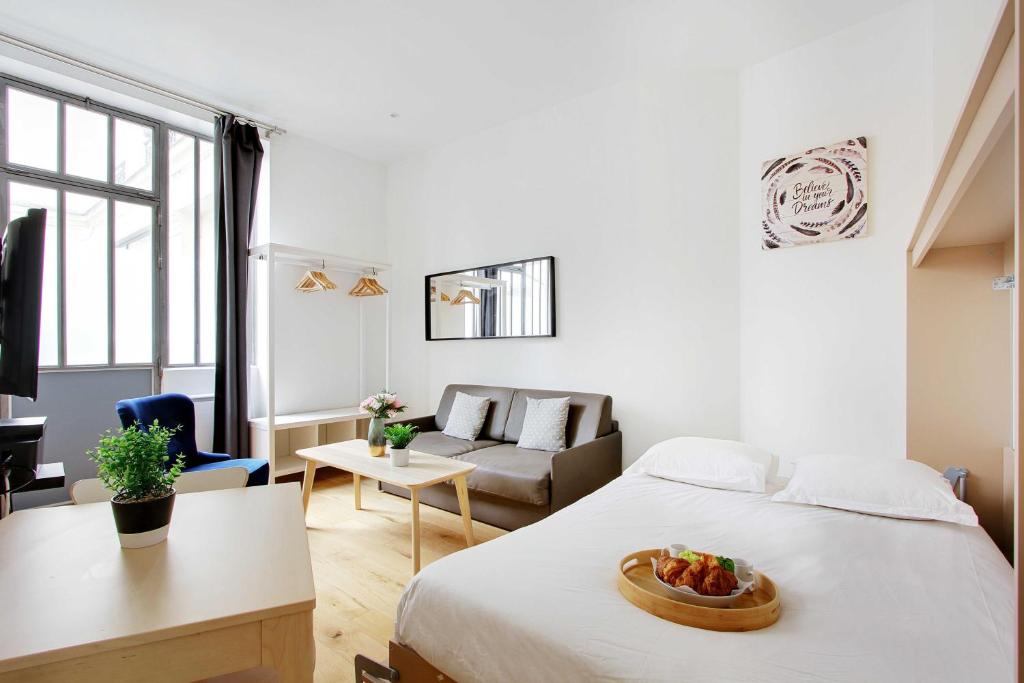 une chambre avec un lit avec un bol de fruits dessus dans l'établissement Charmant Studio au coeur de la vie parisienne, à Paris