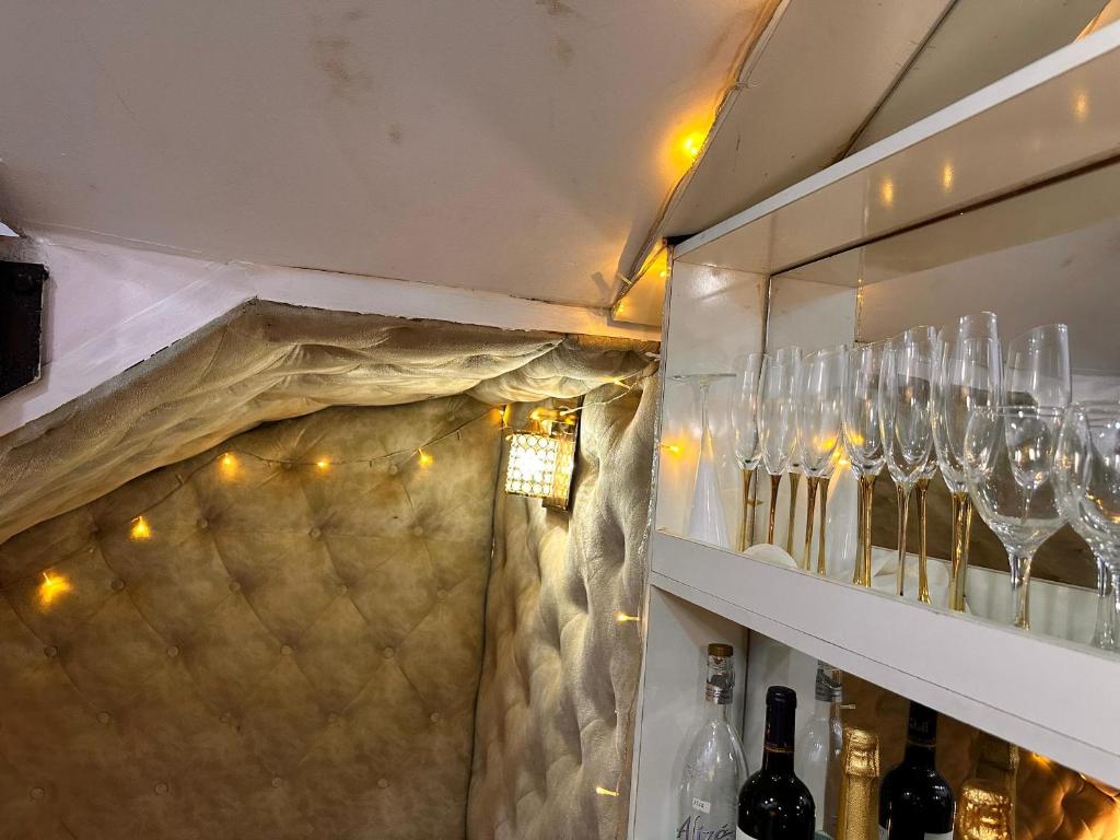 a shelf with wine glasses on it with lights at Savannah Homes in Abuja