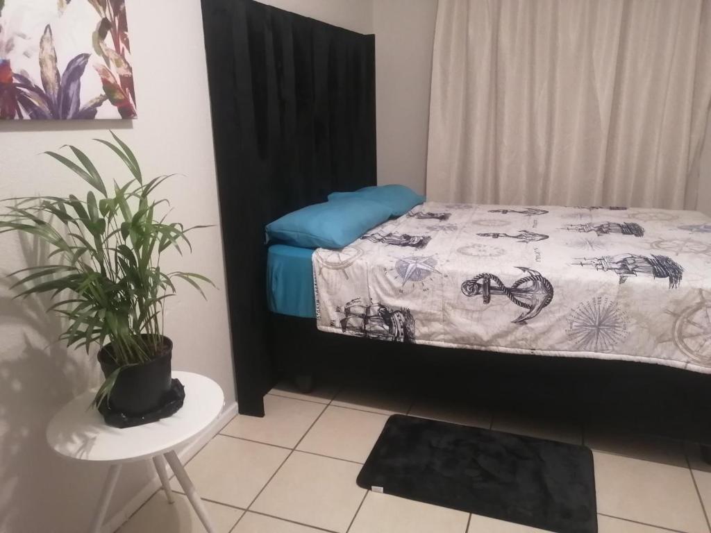 a bedroom with a bed and a potted plant at Ekya in Randburg