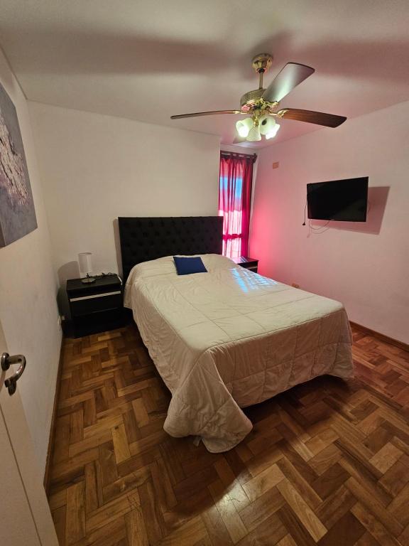 une chambre avec un lit et un ventilateur de plafond dans l'établissement Amplio Depto en Pleno Centro!, à Córdoba