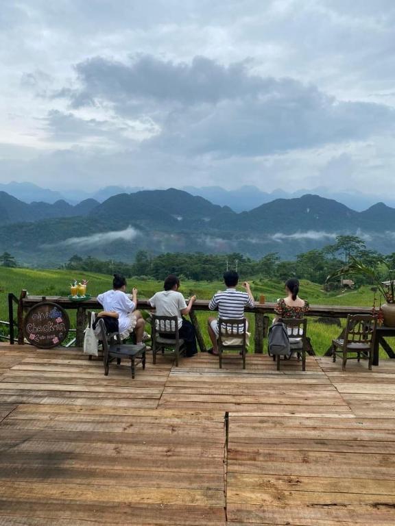 a group of people sitting at a table on a deck at Pu Luong May Home & Cafe in Làng Bang