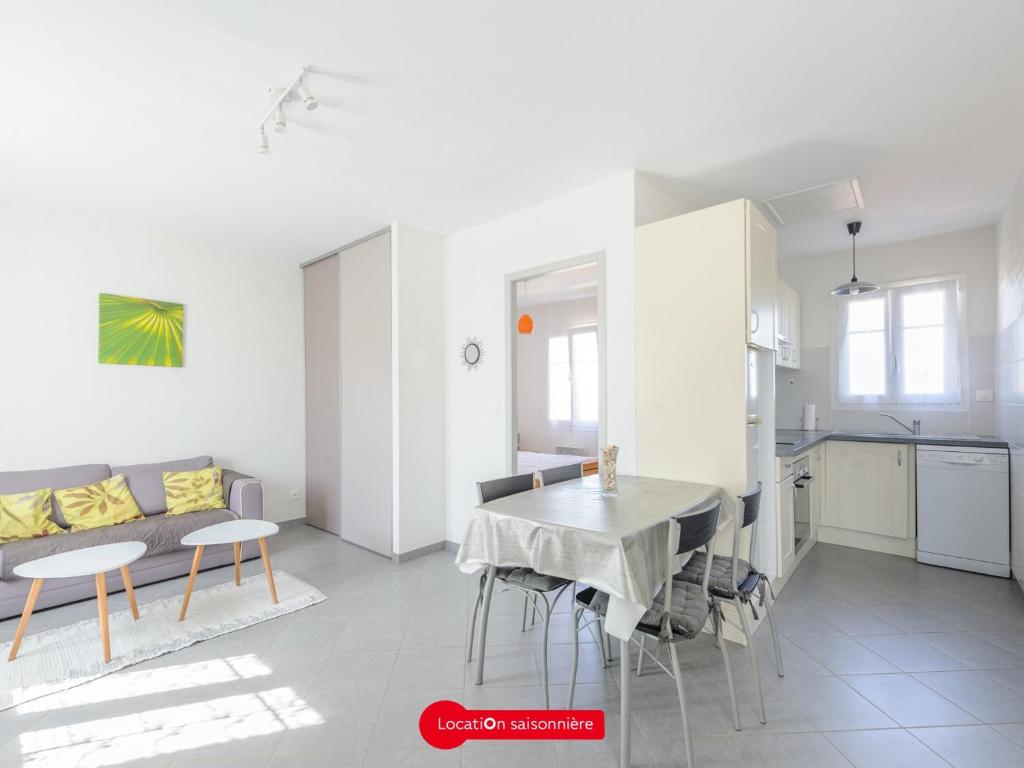 une cuisine et un salon avec une table et un canapé dans l'établissement Appartement T2 à 100m de l'Océan, tout confort avec parking privatif, pour 4 personnes - FR-1-535-58, à Angoulins-sur-Mer