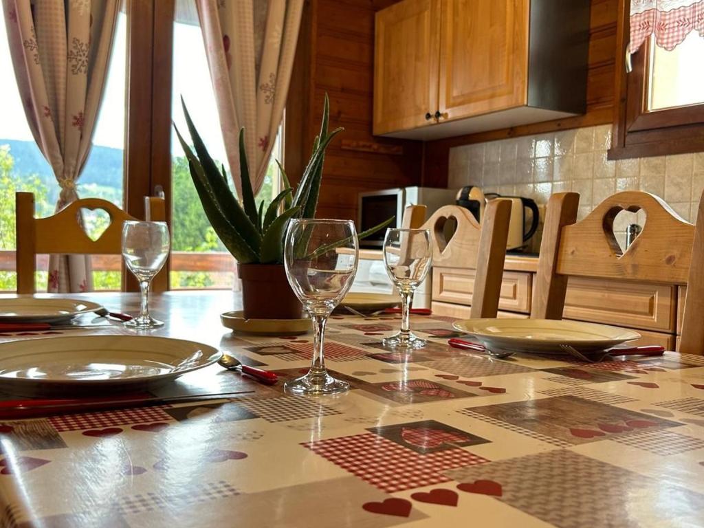 une table de salle à manger avec des verres à vin dessus dans l'établissement Appartement cosy avec parking et terrasse à Gérardmer - FR-1-589-653, à Gérardmer